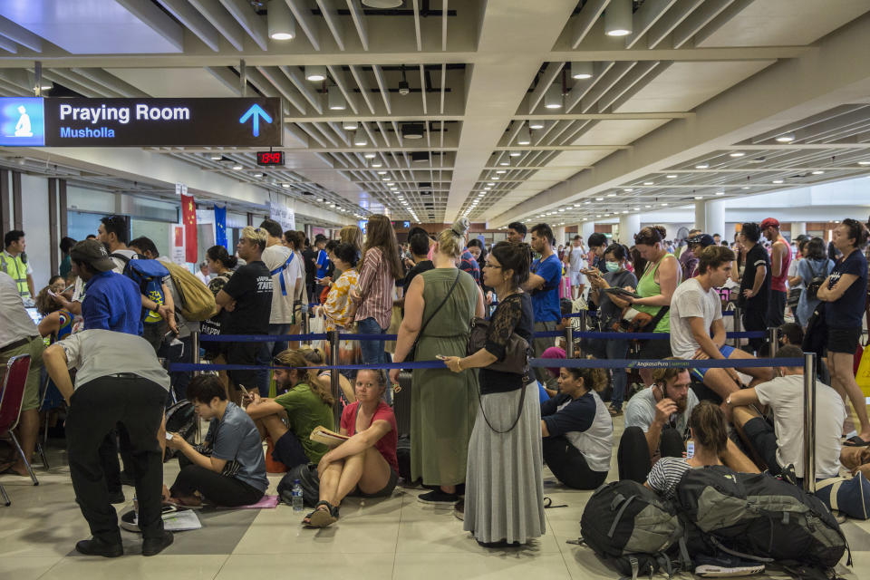 Passengers wait in line&nbsp;at the ticketing counter at Ngurah Rai International Airport near Denpasar, Bali, on Tuesday. The airport has been closed for two days, flights have been canceled and authorities have scrambled to assist stranded passengers. (Photo: Bloomberg via Getty Images)