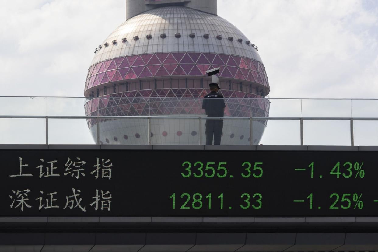 SHANGHAI, CHINA - JULY 06: A security man with protective mask stands on a pedestrian bridge which displays the numbers for the Shanghai Shenzhen stock indexes on July 06, 2022 in Shanghai, China. (Photo by Hugo Hu/Getty Images)