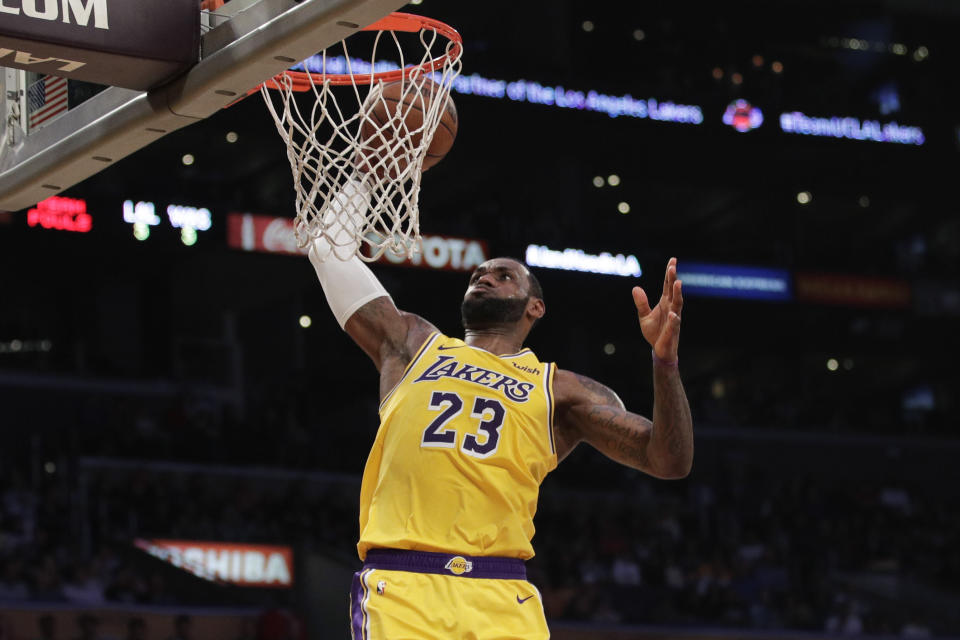 LeBron James, de los Lakers de Los Ángeles, realiza una clavada en el duelo ante los Wizards de Washington, el martes 26 de marzo de 2019 (AP Foto/Jae C. Hong)