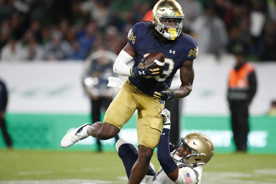 Notre Dame running back Sam Assaf (33) runs past Navy cornerback Elias Larry (3) during the first half of an NCAA college football game in Dublin, Ireland, Aug. 26, 2023. (AP Photo/Peter Morrison)