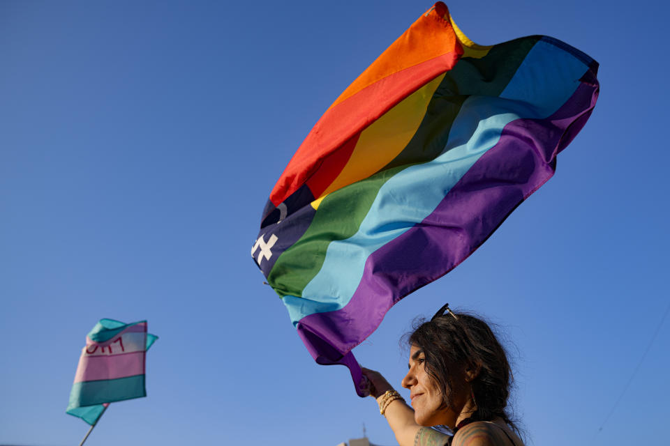 A person waves a rainbow flag during the Bucharest Pride 2021 in Bucharest, Romania, Saturday, Aug. 14, 2021. The 20th anniversary of the abolishment of Article 200, which authorized prison sentences of up to five years for same-sex relations, was one cause for celebration during the gay pride parade and festival held in Romania's capital this month. People danced, waved rainbow flags and watched performances at Bucharest Pride 2021, an event that would have been unimaginable a generation earlier. (AP Photo/Vadim Ghirda)