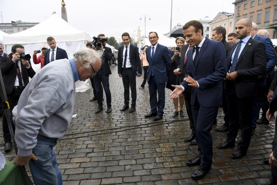 France's President Emmanuel Macron, second right, meets members of the public at a local market area as he is accompanied by Finland's President Sauli Niinisto, outside the Presidential Palace after their joint press conference in Helsinki, Finland, Thursday Aug. 30, 2018. Macron is in Finland on a two-day official visit. (Antti Aimo-Koivisto/Lehtikuva via AP)