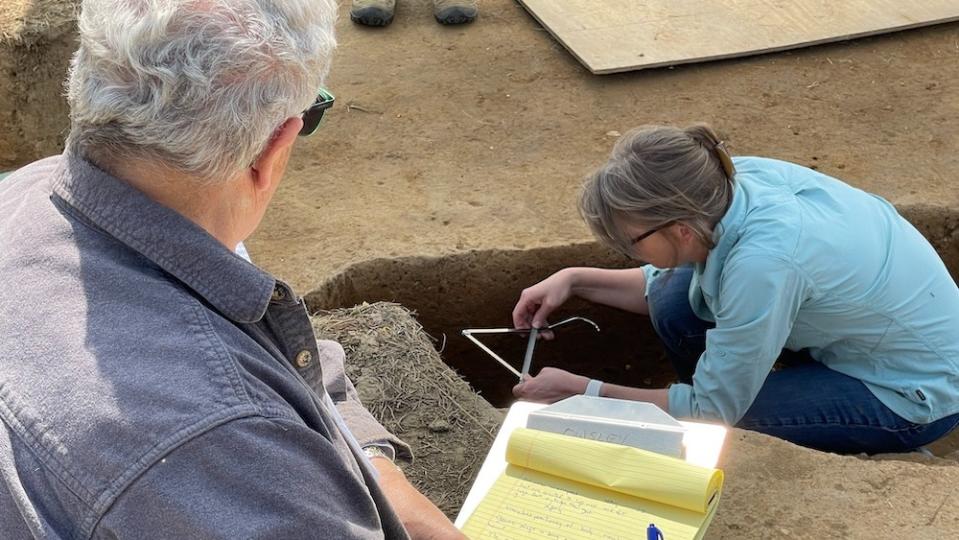 A woman digs at a burial site.