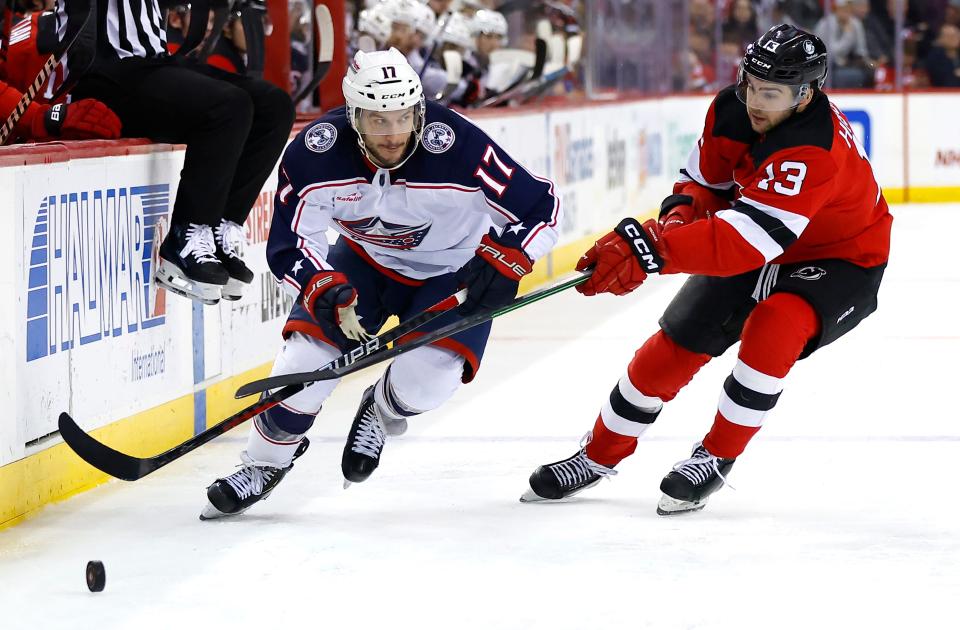 Columbus Blue Jackets right wing Justin Danforth (17) plays the puck against New Jersey Devils center Nico Hischier (13) during the first period of an NHL hockey game Wednesday Dec. 27, 2023, in Newark, N.J. (AP Photo/Noah K. Murray)