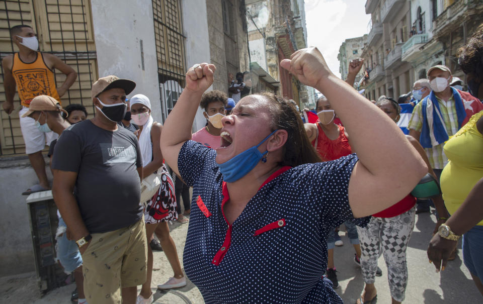 A woman shouts pro-government slogans as anti-government protesters march in Havana, Cuba, Sunday, July 11, 2021. Hundreds of demonstrators took to the streets in several cities in Cuba to protest against ongoing food shortages and high prices of foodstuffs. (AP Photo/Ismael Francisco)