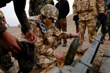 A Romanian military adviser inspects artillery shells before a live-fire exercise with Afghan troops outside Kandahar Air Field, Afghanistan, February 15, 2017. Picture taken February 15, 2017. REUTERS/Josh Smith