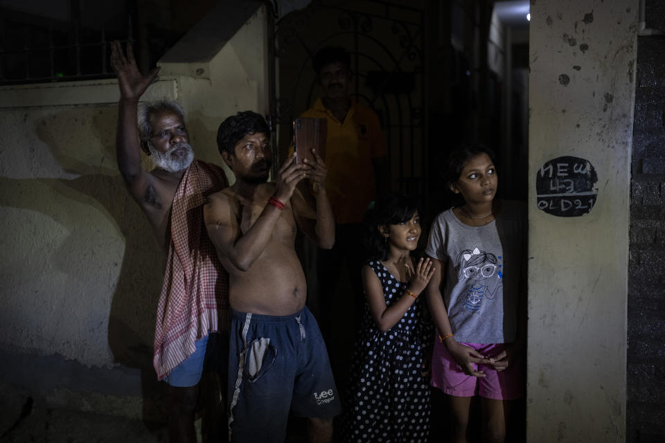 People watch as Dravida Munnetra Kazhagam (DMK) party candidate Dayanidhi Maran's roadshow passes through a residential area ahead of country's general elections, in the southern Indian city of Chennai, April 14, 2024. (AP Photo/Altaf Qadri)