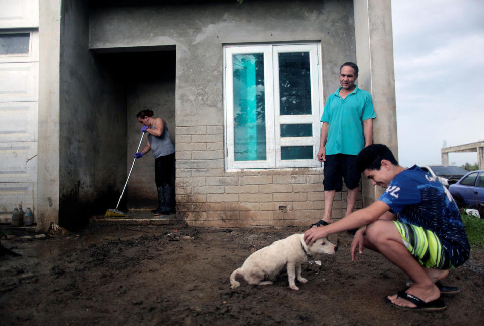 <p>A family is seen in their front yard flooded with mud, after the island was hit by Hurricane Maria in Toa Baja, Puerto Rico, Oct. 16, 2017. (Photo: Alvin Baez/Reuters) </p>