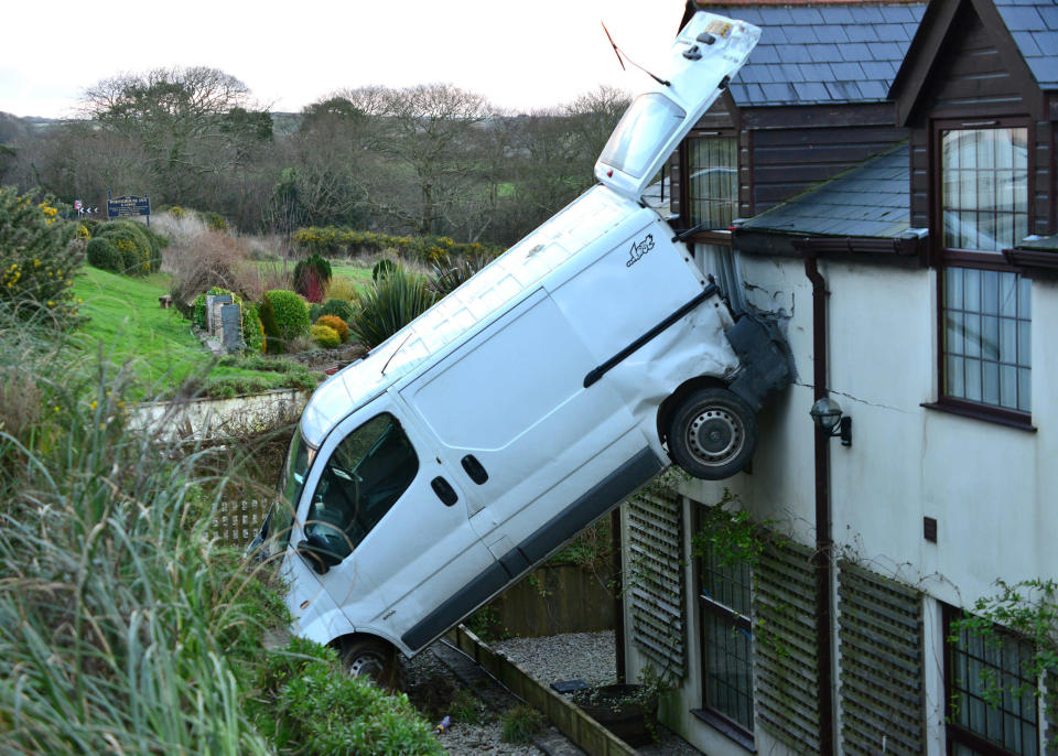 A white van man is lucky to be alive after he crashed his motor, flipping it and landing it vertically against a hotel near Newquay, Cornwall. Luckily no one was hurt. Simon Hill, owner of the White House Inn said: "It could have been very dangerous if there had been someone in that room. They would certainly have got a shock." (SWNS)