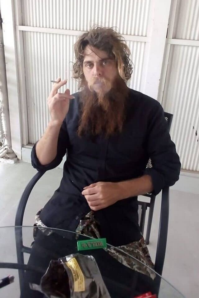 Henry Hammond with long hair and beard smoking a cigarette before he was charged over Courtney Herron's death. Source: AAP