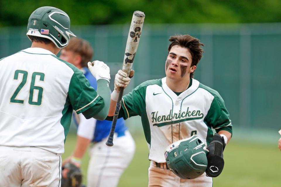 Hendricken's Griffin Crain, right, exchanges congratulations with teammate Cole Hambly during a game last June.