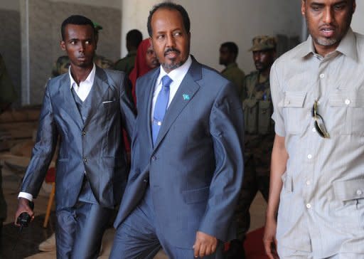 Newly elected Somalia President Hassan Sheikh Mohamud (C) leaves the Jazeera Hotel in Mogadishu after a bomb blast outside the venue