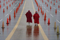 FILE - In this Aug. 29, 2020, file photo, fans walk through a parking lot at Arrowhead Stadium marked with traffic cones to keep fans from parking too close together during NFL football training camp for the Kansas City Chiefs in Kansas City, Mo. A football-starved nation is getting its games back with the start of the NFL season, but many worry that attending games or get-togethers will lead to a new surge in coronavirus infections. NFL football will kick off Thursday, Sept. 10, in Kansas City at a stadium that's allowing 17,000 fans inside. (AP Photo/Charlie Riedel, File)