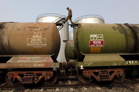 A worker walks atop a tanker wagon to check the freight level at an oil terminal on the outskirts of Kolkata, November 27, 2013. REUTERS/Rupak De Chowdhuri/Files