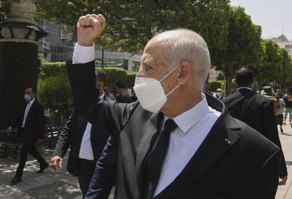 FILE - In this Sunday, Aug. 1, 2021 file photo, Tunisian President Kais Saied raises his fist to bystanders as he stroll along the avenue Bourguiba in Tunis, Tunisia. Tunisia remains in limbo more than a week after President Kais Saied fired the prime minister, froze parliament and took on executive powers. Some citizens worried about what comes next, and when it will happen, as pressure for decisions mounts. (Slim Abid/Tunisian Presidency via AP, File)