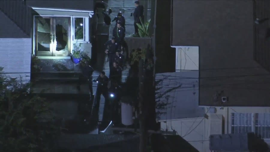 Officers investigating a home invasion in L.A. seen approaching the back of a residence with their guns drawn on July 17, 2024. (Sky5)