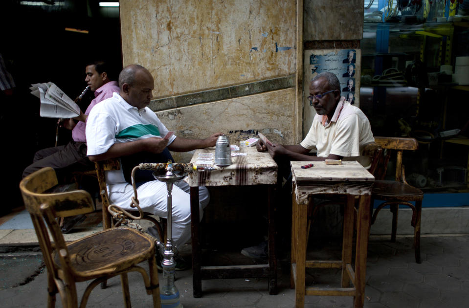 Two Egyptian men play cards at a local coffee shop in downtown Cairo, Egypt, Wednesday, Oct. 31, 2012. Egypt’s capital prides itself on being city that never sleeps, with crowds filling cafes and shops open into the small hours. So the government is facing a backlash from businesses and the public as it vows to impose new nationwide rules closing stores and restaurants early. Officials say the crisis-ridden nation has to conserve electricity, but they also seem intent on taming a population they see as too unruly. (AP Photo/Nasser Nasser)