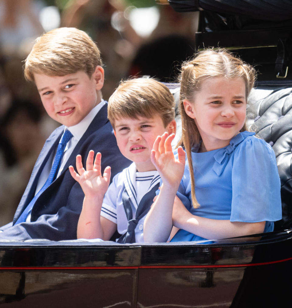 Prince George, Prince Louis and Princess Charlotte in a carriage waving. 