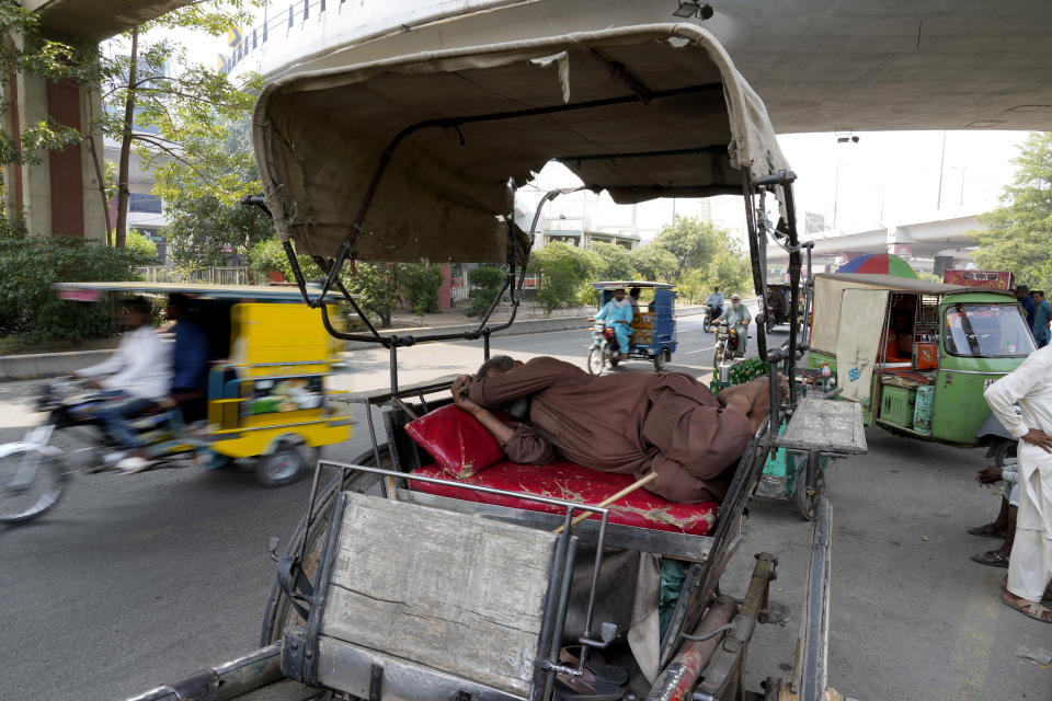 A man takes a nap on his horse-cart parked under a bridge during a hot summer day, in Lahore, Pakistan, Thursday, May 23, 2024. Doctors treated hundreds of victims of heatstroke at hospitals across Pakistan on Thursday after an intense heat wave sent temperatures above normal levels due to climate change, officials said. (AP Photo/K.M. Chaudhry)