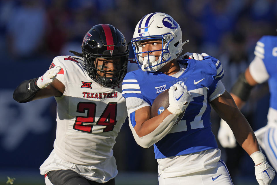 FILE - Texas Tech defensive back Malik Dunlap (24) tackles BYU running back LJ Martin (27) during the first half of an NCAA college football game Saturday, Oct. 21, 2023, in Provo, Utah. Martin ran for a team-high 518 yards as a freshman last season, and with experience could be the key to reviving what was one of the worst FBS rushing offenses as the Cougars finished 4-8 in their first Big 12 season. (AP Photo/Rick Bowmer, File)