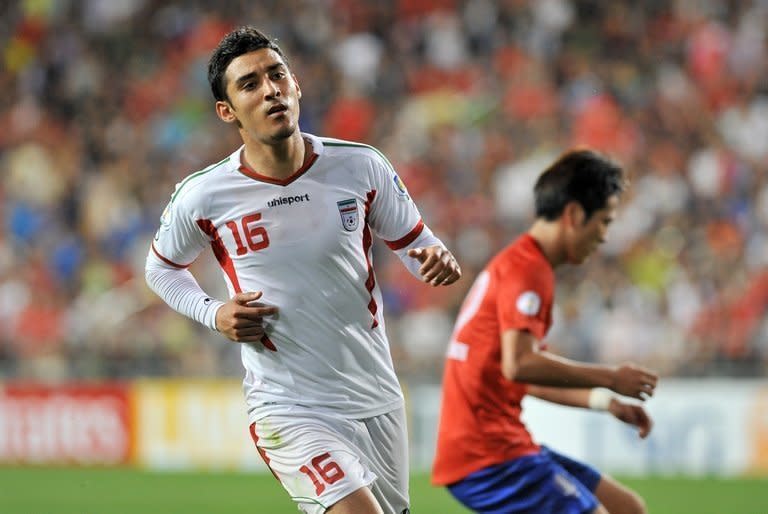 Iran's forward Reza Ghoochannejhad (L) celebrates after scoring against South Korea during their World Cup qualifier match against South Korea in Ulsan, southeast of Seoul on June 18, 2013. Iran won the match 1-0