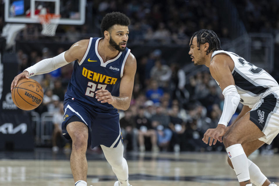 Denver Nuggets guard Jamal Murray, left, looks past San Antonio Spurs guard Tre Jones, right, during the first half of an NBA basketball game, Friday, March 15, 2024, in Austin, Texas. (AP Photo/Stephen Spillman)