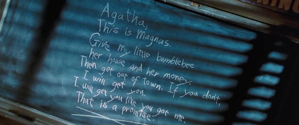 A blackboard with writing on it, including "Agatha, this is Magnus; give my little bumblebee her house and her money"