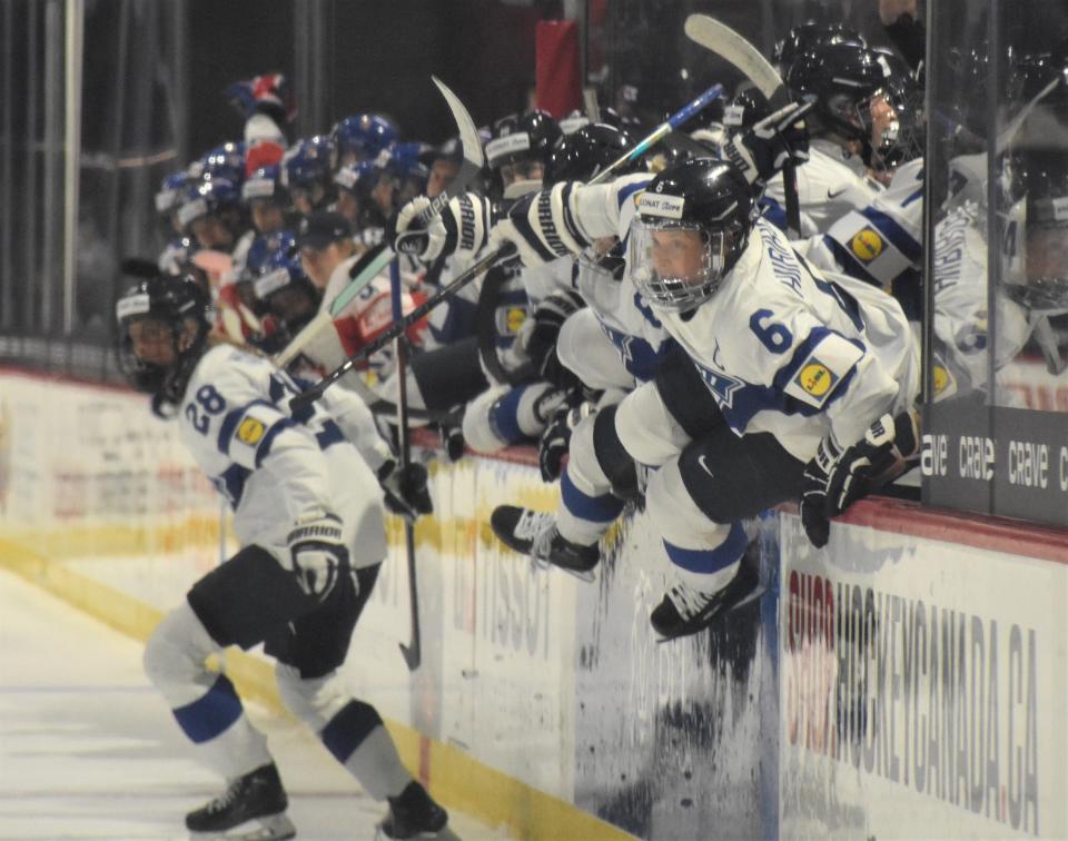 Jenniina Nylund (28) and Jenni Hiirikoski (6) lead Finland's players over the boards and out from the bench for the celebration at the end of the bronze medal game at the IHF Women's World Championship in Utica Sunday.