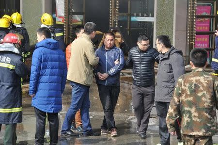 A man was taken away by police from HNA Hotel after a fire broke out in Nanchang, Jiangxi province, February 25, 2017. REUTERS/Stringer
