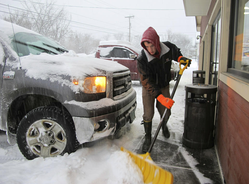 Carter Martin shovels a sidewalk at Maplefields store and gas station on Sunday, Jan. 20, 2019, in Plainfield, Vt. A major winter storm that blanketed most of the Midwest with snow earlier in the weekend barreled toward New England Sunday, where it was expected to cause transportation havoc ranging from slick and clogged roads to hundreds of cancelled airline flights. (AP Photo/Lisa Rathke)