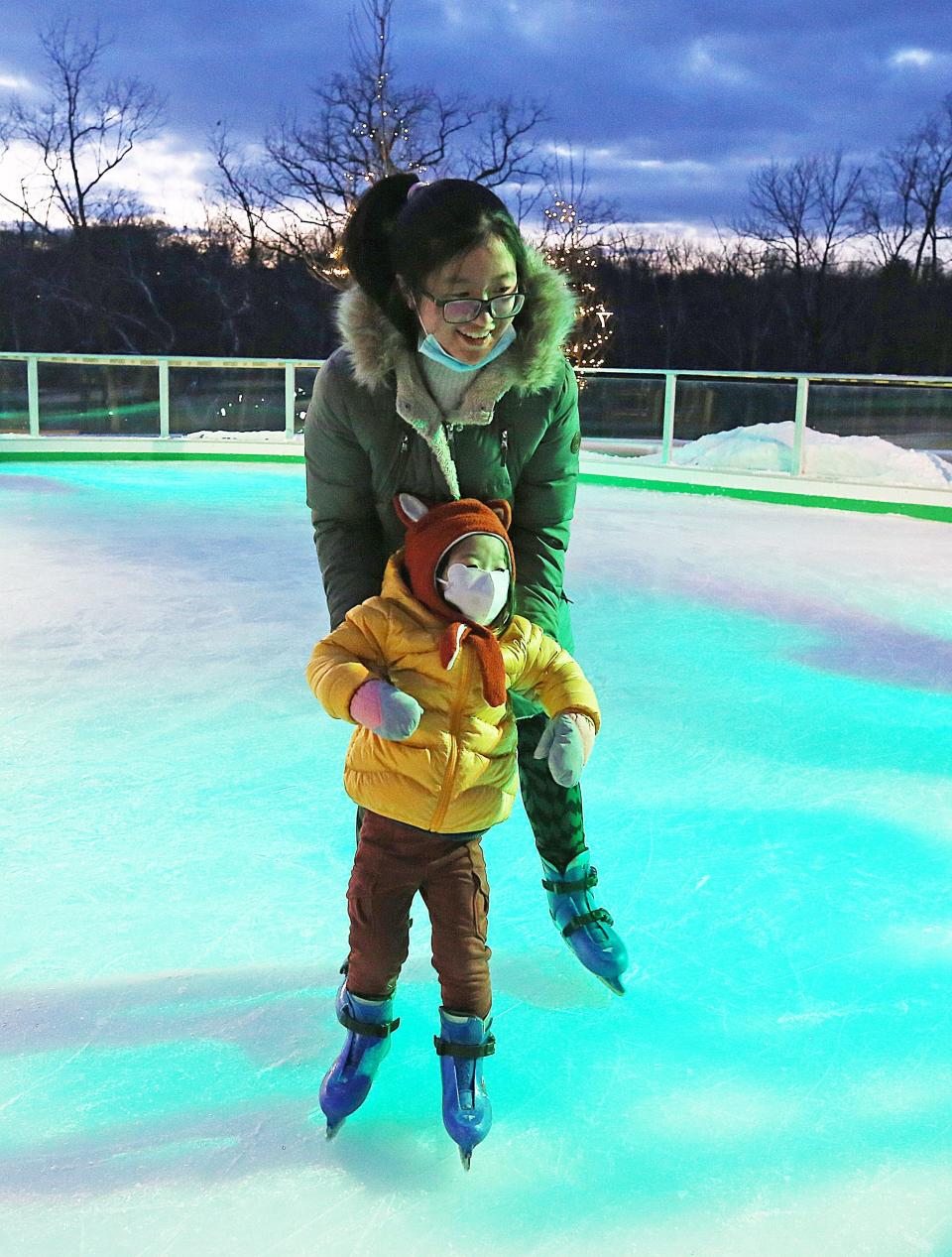 Helen Tang helps her daughter, Alaine, 3, learn to skate.