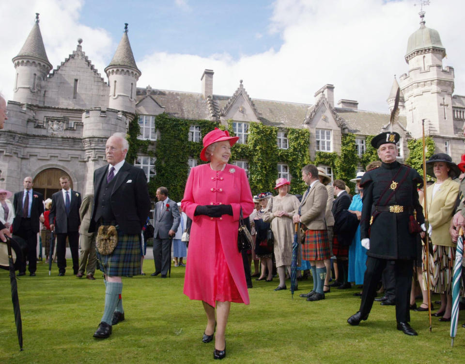 The final day of the Golden Jubilee tour ends with a Garden Party in the grounds of the Queen's home at Balmoral Castle. Queen Elizabeth II walks through the gardens to meet some of her 3,000 guests. On her right, dressed in traditional uniform with a distinctive feathered cap, is a member of the Royal Company of Archers, who act as the Queen's official bodyguards when she is in Scotland. (Photo by © Pool Photograph/Corbis/Corbis via Getty Images)