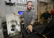 In this photo taken May 23, 2019, Ryan Smith, a test engineer at VICIS, a Seattle-based company that makes football helmets, runs a head-to-helmet impact test in a testing lab in Seattle. The company's latest offering is the ULTIM cap, which is intended for use with youth flag football and competitive 7-on-7 football played during the offseason for youth and high school programs. (AP Photo/Ted S. Warren)