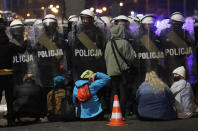 A police cordon guards the house of Poland's ruling conservative party leader Jaroslaw Kaczynski against a crowd protesting a decision by the Constitutional Court, in Warsaw, Poland, on Friday, Oct. 23, 2020. Poland’s top court ruled Thursday that a law allowing abortion of fetuses with congenital defects is unconstitutional, shutting a major loophole in the predominantly Catholic country's abortion laws that are among the strictest in Europe. Defying the pandemic-related ban on gatherings, the protesters chanted for the government to resign. (AP Photo/Czarek Sokolowski)