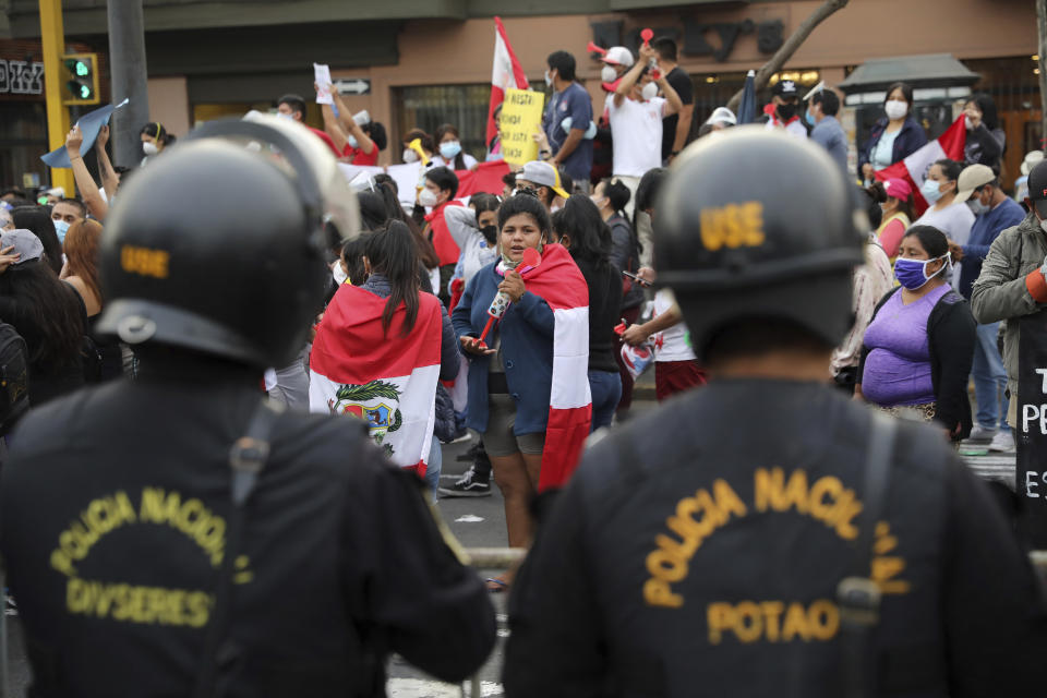 People celebrate in the street after Peru's new interim President Francisco Sagasti was designated by Congress to lead the nation, in Lima, Peru, Monday, Nov. 16, 2020. Lawmakers chose Sagasti to become the nation's third president in the span of a week after they ousted Martin Vizcarra and the following protests forced his successor Manuel Merino to resign. (AP Photo/Rodrigo Abd)