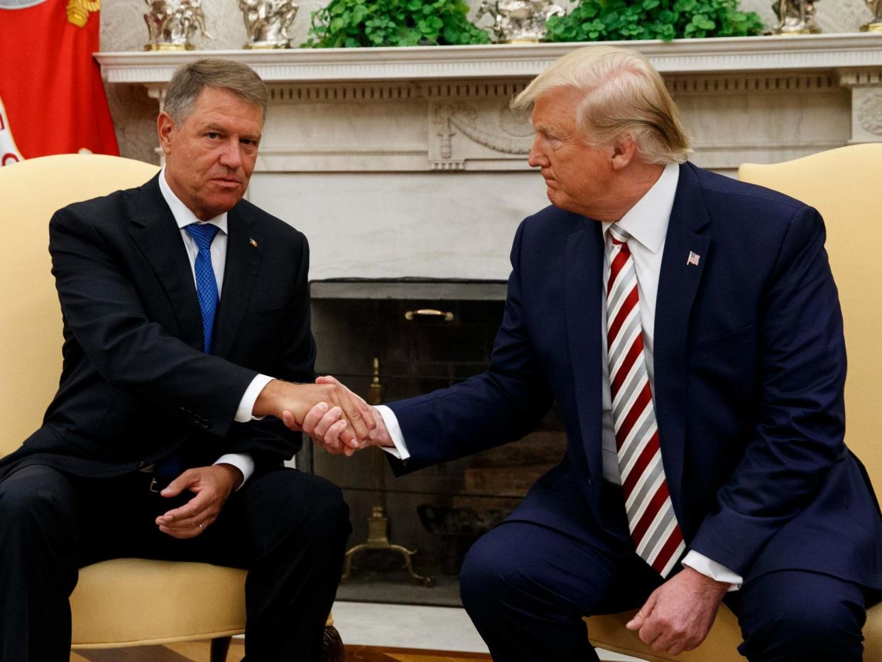 President Donald Trump and Romanian President Klaus Iohannis shake hands during a meeting in the Oval Office: AP