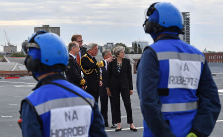 Britain's Prime Minister Theresa May stands on the flight deck as she speaks to crew members of the British aircraft carrier HMS Queen Elizabeth, during her tour of the ship, after it arrived at Portsmouth Naval base, its new home port, in Portsmouth, Britain August 16, 2017. REUTERS/Ben Stansall/Pool