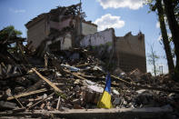 A torn Ukraine flag waves among debris in a school destroyed in a Russian bombing in Bakhmut, eastern Ukraine, Tuesday, May 24, 2022. The town of Bakhmut has been coming under increasing artillery strikes, particularly over the last week, as Russian forces try to press forward to encircle the city of Sieverodonetsk to the northeast. (AP Photo/Francisco Seco)