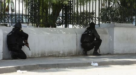 Police officers crouch on the pavement outside parliament in Tunis March 18, 2015. REUTERS/Zoubeir Souissi