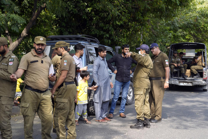 Police officers search a man at a temporary checkpoint around the home of Pakistan's former Prime Minister Imran Khan, in Lahore, Pakistan, Wednesday, May 17, 2023. Police surrounded the home of former Prime Minister Khan on Wednesday, claiming he was sheltering dozens of people allegedly involved in violent protests over his recent detention. (AP Photo/K.M. Chaudary)