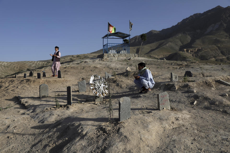 Afghan men prays near the grave of their relatives killed in bombings near Syed Al-Shahada School last month at cemetery on the outskirts of Kabul, Afghanistan, Wednesday, June 2, 2021. After the collapse of the Taliban 20 years ago, Afghanistan's ethnic Hazaras began to flourish and soon advanced in various fields, including education and sports, and moved up the ladder of success. They now fear those gains will be lost to chaos and war after the final withdrawal of American and NATO troops from Afghanistan this summer. (AP Photo/Rahmat Gul)