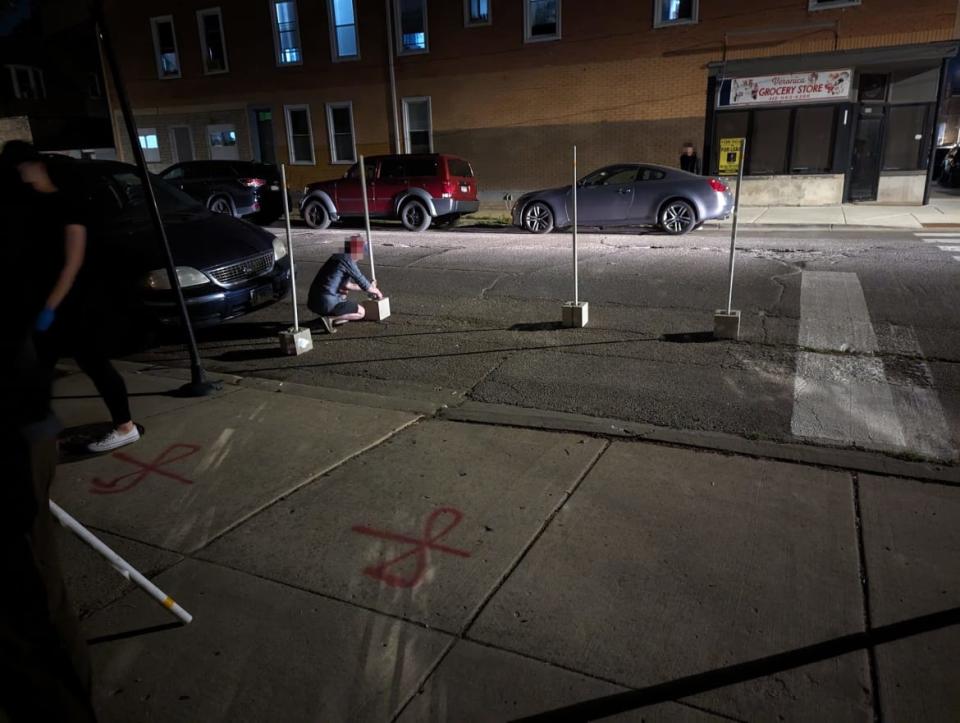 Two members of the People's CDOT work to set up the traffic calming installation at a crosswalk in Chicago's South Side. 