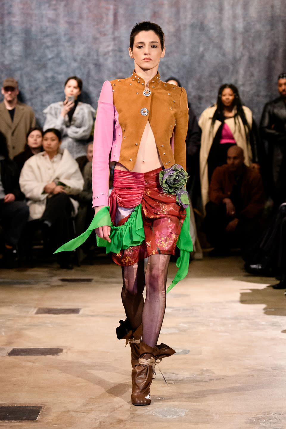a model walks the runway in a patchwork look