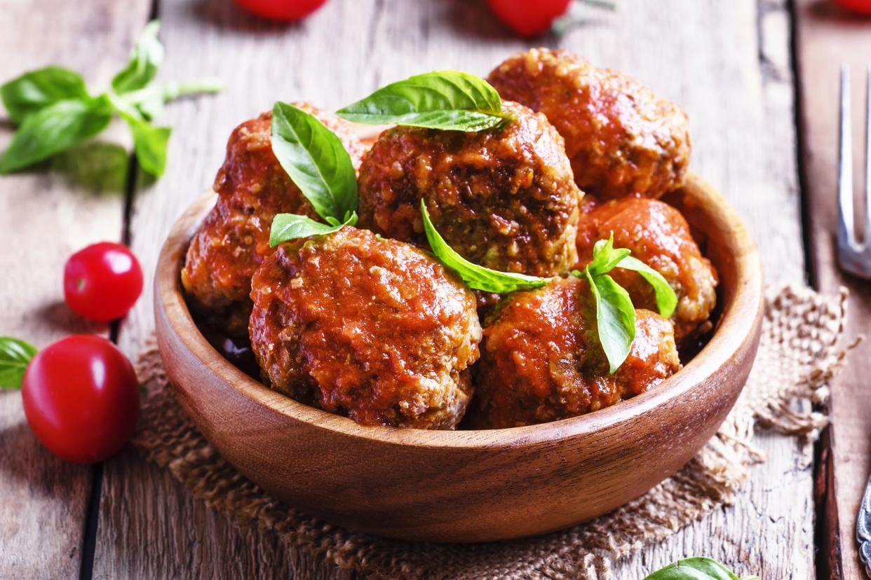 Chipotle Meatballs in wood bowl garnished fresh basil