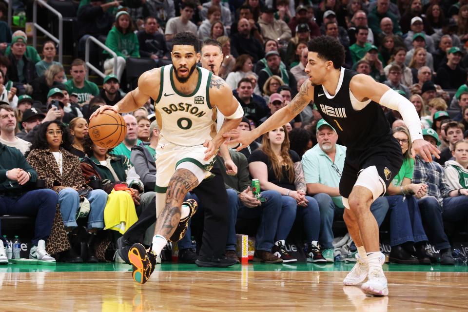 BOSTON, MASSACHUSETTS - FEBRUARY 04: Jayson Tatum #0 of the Boston Celtics drives to the basket defended by Scotty Pippen Jr #1 of the Memphis Grizzlies during the first half at TD Garden on February 04, 2024. (Photo by Paul Rutherford/Getty Images)