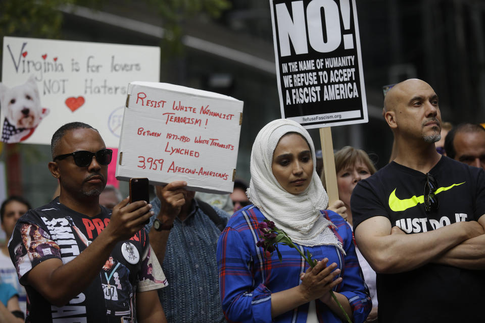 People hold signs at a vigil on Aug. 13 in Chicago for the victims in the previous day's violent clashes in Charlottesville.