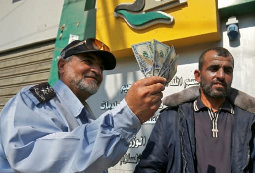 A Palestinian man shows his money after receiving his salary in Rafah in the southern Gaza Strip November 9, 2018