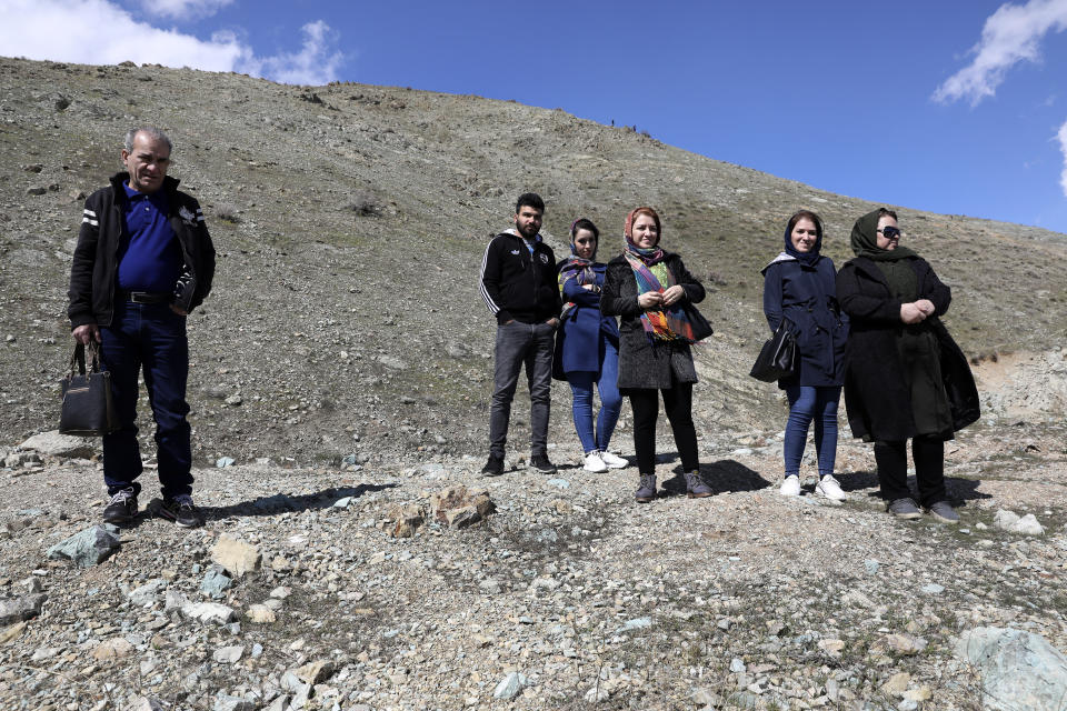 People look out over Tehran from the foothills of the Alborz mountain range north of the city as they spend their New Year, or Nowruz, holidays, Iran, Tuesday, March 31, 2020. In recent days, Iran which is battling the worst new coronavirus outbreak in the region, has ordered the closure of nonessential businesses and banned intercity travels aimed at preventing the virus' spread. (AP Photo/Vahid Salemi)