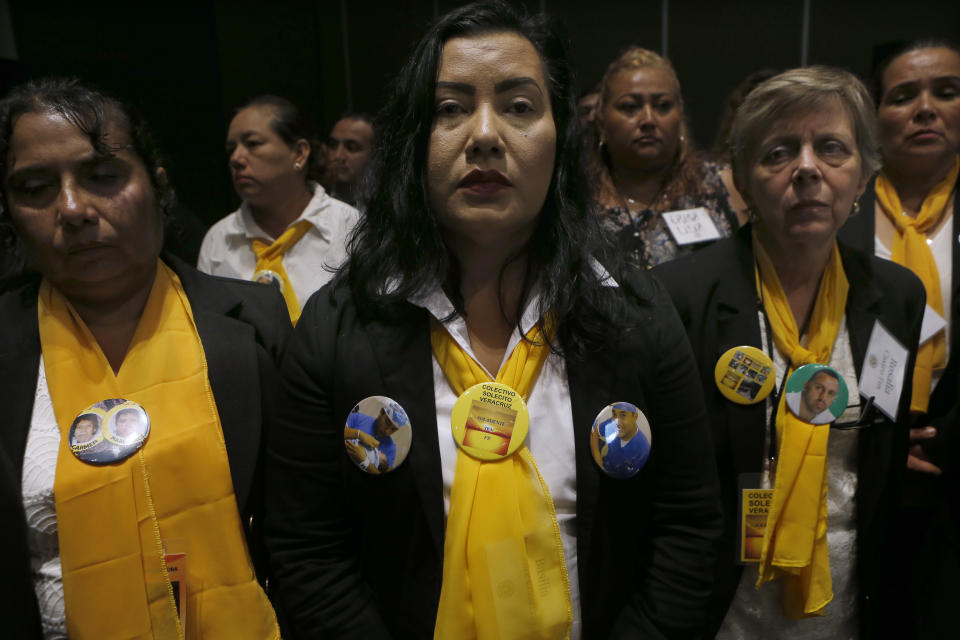 Women with the volunteer group "Colectivo Solecito," or Little Sun Collective, wear photos of their missing relatives during an award ceremony in Mexico City, Tuesday, Oct. 16, 2018. The University of Notre Dame has presented its 2018 Notre Dame Award to the group of Mexican mothers who have led a tireless, years-long search for missing loved ones in the Gulf coast state of Veracruz. (AP Photo/Marco Ugarte)