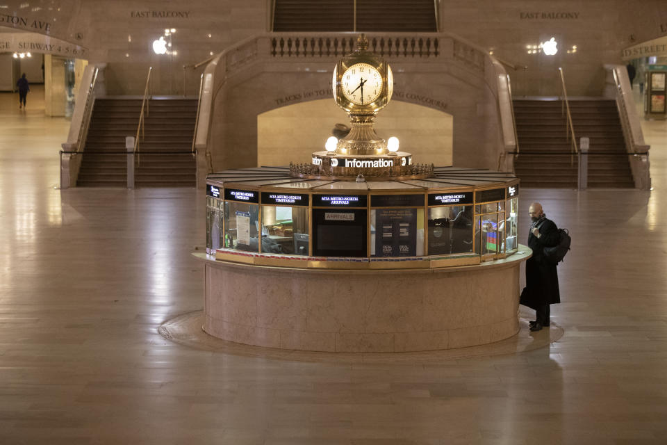 A traveler stands at the information desk at Grand Central Terminal, Tuesday, March 17, 2020, in New York. As of Sunday, nearly 2,000 people with the virus have been hospitalized in the state of New York and 114 have died, officials said. More than 15,000 have tested positive statewide, including 9,000 in New York City. (AP Photo/Mary Altaffer)